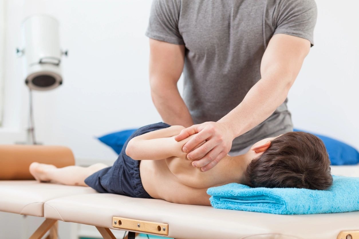 Sports chiropractor working with young athlete